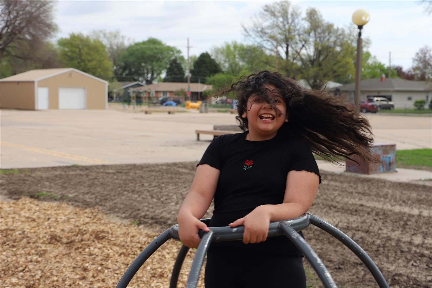 Smiling Newell 5th Grader on the playground spinning globe.